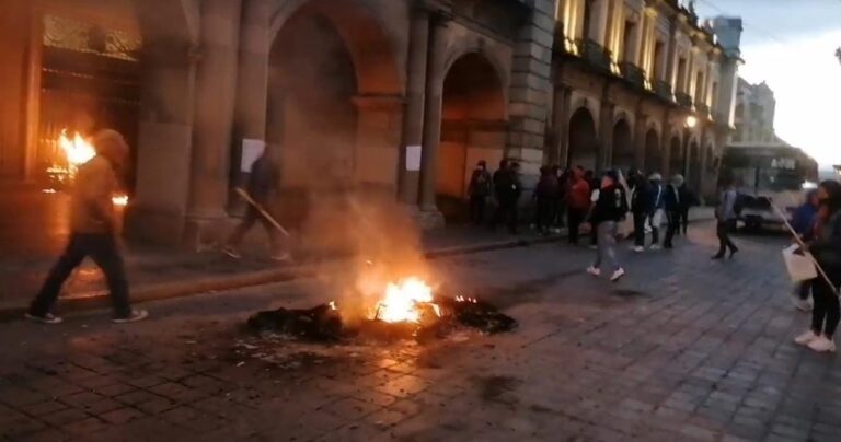 Normalistas queman puerta del Palacio de Gobierno de Oaxaca
